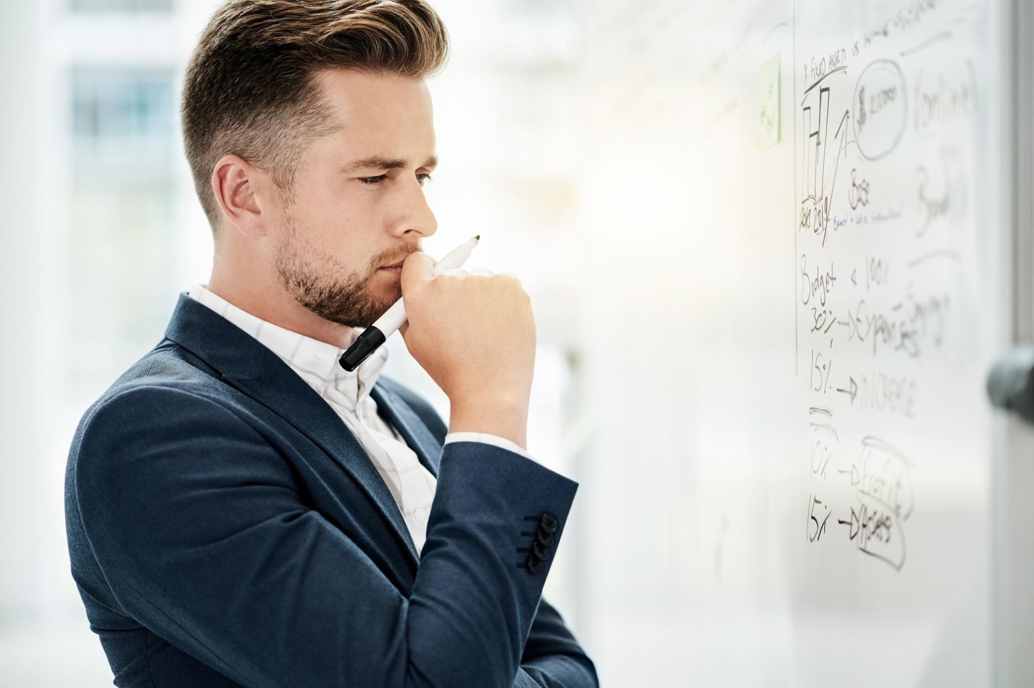 Thoughtful professional examining an organizational problem at a whiteboard